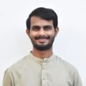 Nikhil Udayabhanu smiling against a plain white wall